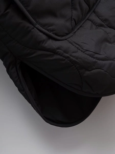 Detail shot of black quilted fabric with fine stitching on a casual padded winter jacket