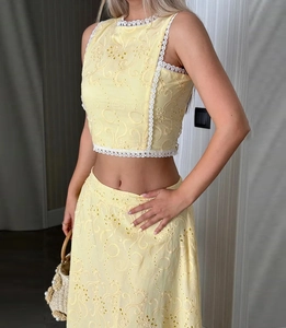 Détail du haut sans manches et de la jupe jaune clair avec broderie ajourée délicate
