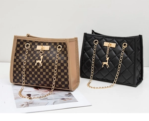 Detail of brown monogram and black quilted shoulder bags with gold deer charms