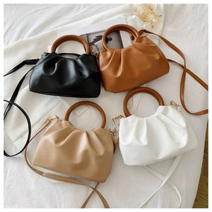 Close-up of ruched cloud bags in four colors with vintage round wooden handles and straps