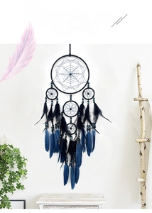 Détail d'un attrape-rêves artisanal avec plumes bleues et noires et perles turquoises