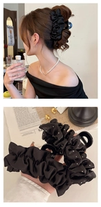 Grande pince à cheveux en satin plissé noir avec strass portée sur la chevelure