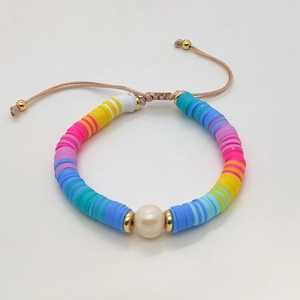 Detail of colorful handmade Heishi bead bracelet with a central white freshwater pearl