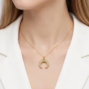 Elegant gold horn pendant necklace with sparkling micro-pave cubic zirconia on a female model