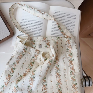 Detail of floral cotton tote bag featuring magnetic closure and inner texture