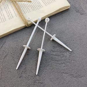 Detailed view of three white plastic cake topper base stakes with rings on gray background