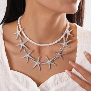 Detail of double-layer necklace with faux pearls and sparkling rhinestone starfish pendants