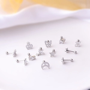 Detailed macro shot of silver 20G titanium steel ear studs with zircon butterfly and crown shapes