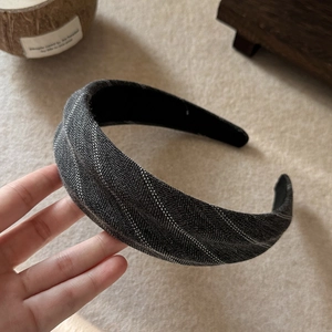Detail of grey herringbone fabric headband with non-slip lining and premium stitching