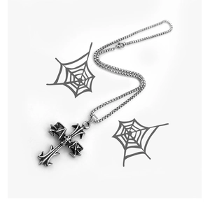 Detail of silver stainless steel gothic skull cross pendant with wings on white background