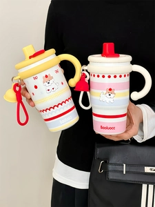 Close-up of portable cartoon mugs with handles in pink and yellow with ceramic liners