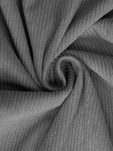 Gros plan macro du tissu en velours côtelé gris montrant les rayures douces et la texture dense