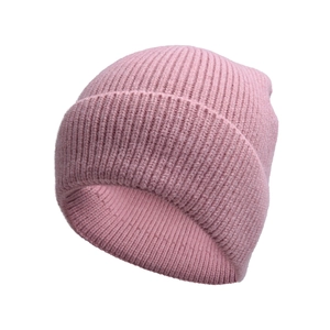 Dettaglio del berretto in maglia rosa con spesse coste verticali e ampio bordo risvoltato