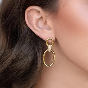 Polished 18K gold double hoop earrings with pavé zircon link on female model