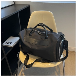Close-up of black waterproof gym bag with leather patch on a stylish white chair