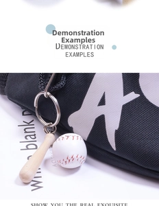 Close-up of a mini wooden baseball bat and ball keychain hanging on a black canvas bag