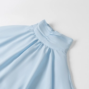 Close-up of the ruffled stand collar and pleated neck detail on blue chiffon blouse