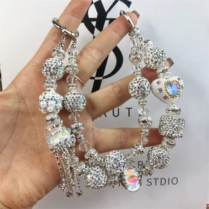 Close-up of sparkling rhinestone beads and crystal heart charm with silver metal tassels
