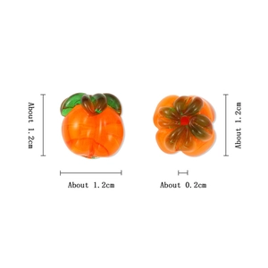 Macro shot of 1.2cm orange glass pumpkin beads with green leaves for DIY jewelry making
