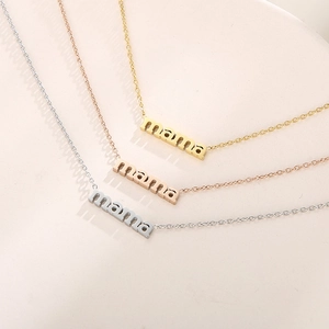 Three mama pendant necklaces in gold, rose gold, and silver finishes displayed together