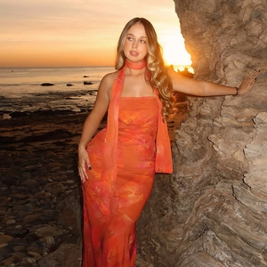 Robe longue bandeau à imprimé fleuri avec écharpe assortie sur une plage au coucher du soleil