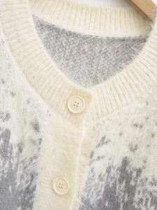 Detail of V-neck cardigan featuring soft mohair texture and beige four-hole buttons