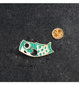 Detail of green and white enamel koi fish brooch with golden butterfly clutch pin back