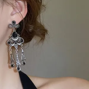 Vintage silver tassel earrings with black gemstones on model in side view close-up
