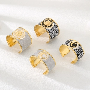 Macro detail of bohemian gold sun and moon bracelets with leopard print and glitter textures