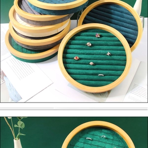 Macro detail of round wooden jewelry tray with velvet slots for rings and earrings display