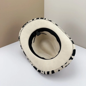 Interior detail view of a retro wool felt cowboy hat with cow print pattern brim