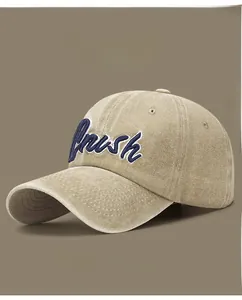 Macro detail of 'Brush' cursive embroidery on a vintage washed khaki baseball cap
