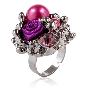 Détail d'une bague rose et perles avec fleur en tissu violet et cristaux roses