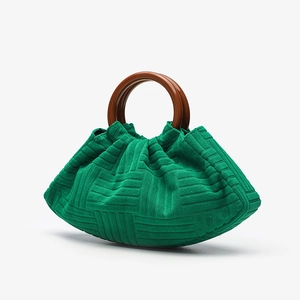 Detailed close-up of green pleated cloud bag texture and its brown round handle
