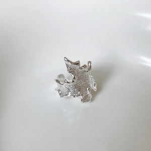 Detail of silver wavy lava texture ring with metallic mirror finish on white background