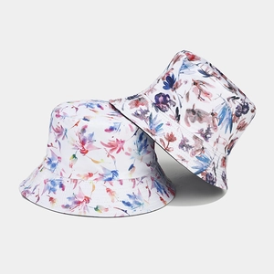 Détail d'un chapeau bob à motif floral réversible avec fleurs roses et bleues