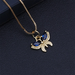 Close-up of gold butterfly pendant featuring blue marquise crystals on a gold chain