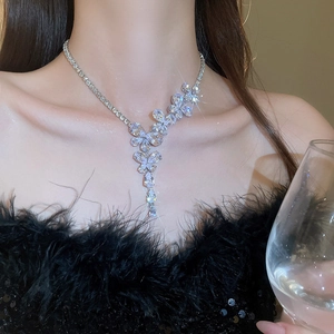 Collana finitura argento con farfalla e fiori in zircone scintillante indossata da modella