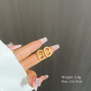 Detail of gold titanium steel pig nose stud earrings held in hand with size info