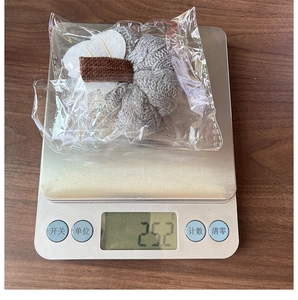 Weight measurement of a grey knitted pumpkin decor showing 25.2g on a digital scale