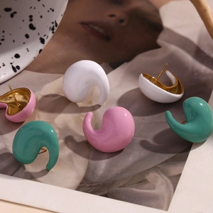 Macro detail of colorful droplet stud earrings in white, pink, and green enamel finish
