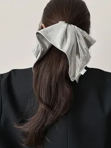 Silver metallic oversized bow scrunchie with long ribbons on a low ponytail hair style