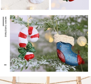 Detailed close-up of resin candy cane and stocking ornaments on a snowy Christmas tree branch