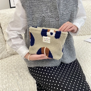 Detail of plush lamb wool makeup bag with polka dots showing smooth zipper closure