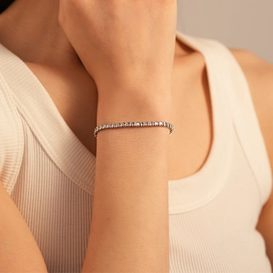 Close-up of elegant silver tennis bracelet with cubic zirconia stones on wrist