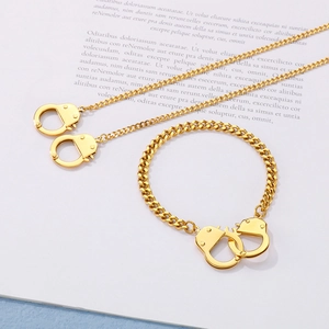 Minimalist gold handcuffed jewelry set featuring a curb chain necklace and matching bracelet