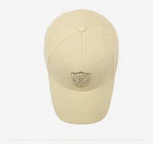 Top-down view showing detailed shield embroidery on beige cotton twill baseball cap