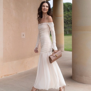 Détail d'une robe longue plissée beige à épaules dénudées avec des manches longues élégantes