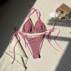Dettaglio della trama del bikini a righe con stella marina e conchiglie su tessuto