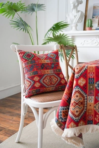 Detailed view of red ethnic jacquard fabric with geometric patterns on a dining chair